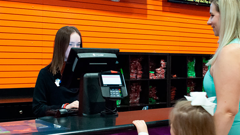 Employee At Register Assisting Guests
